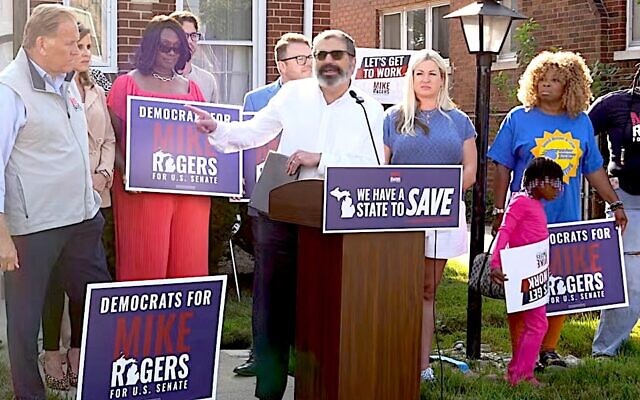 Republican U.S. Senate candidate Mike Rogers, at left, looks on as Rabbi Asher Lopatin, the former director of Community Relations at the Jewish Federation of Greater Ann Arbor, speaks in support of his campaign in Detroit, Michigan, Aug. 20, 2026. (Screenshot via YouTube)