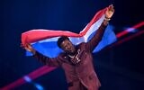 Dutch singer Claude Kiambe parades during the flag ceremony prior to the grand final of the Eurovision Song Contest 2025 at the St. Jakobshalle arena in Basel, May 17, 2025. (Fabrice COFFRINI / AFP)
