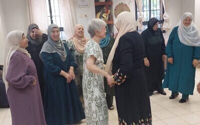 Israeli poet Hamutal Bar-Yosef greets Palestinian neighbors. (Courtesy of Sheep Meadow Press, via the Forward)
