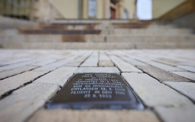 A Stolperstein commemorating Nazi victim Paul Gröger is embedded in the sidewalk in front of City Hall. (Robert Michael/picture alliance via Getty Images)