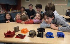 Unified Religious School students pose with 3-D printed sukkahs. (File photo)