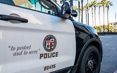 Los Angeles, USA - Close-up on the insignia and slogan of a LAPD vehicle, with the reflection of Union Station's tower visible in the car's window. (Getty Images)
