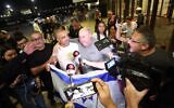 Yaniv Hayun (C), one of the men who helped incapacitate the attacker on the flydubai aircraft bound for Israel from the United Arab Emirates, which was diverted to Saudi Arabia following an emergency signal, is welcomed after arriving at the Ben Gurion International Airport. (Jamal Awad/picture alliance via Getty Images)
