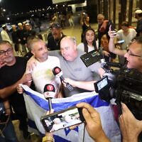 Yaniv Hayun (C), one of the men who helped incapacitate the attacker on the flydubai aircraft bound for Israel from the United Arab Emirates, which was diverted to Saudi Arabia following an emergency signal, is welcomed after arriving at the Ben Gurion International Airport. (Jamal Awad/picture alliance via Getty Images)