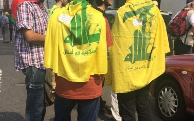Hezbollah flags draped over teenagers at the Al Quds Day march