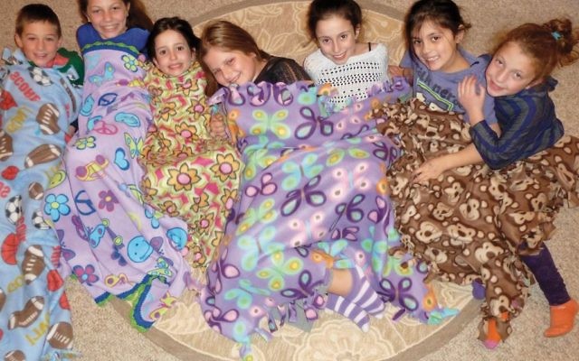 Hayden, Rosenthul, Maron and Paulen children with handmade blankets that will go to needy youngsters.