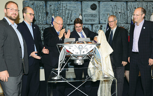 Israel’s President Reuven Rivlin, center left, is among the onlookers as the spacecraft prototype is unveiled. Alon Hadar
