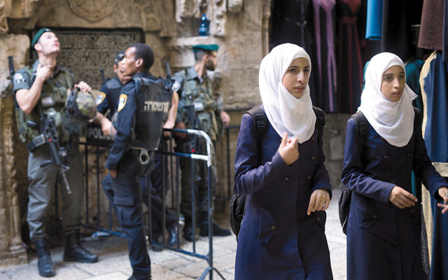 Palestinian women pass an Israeli police checkpoint 
in Jerusalem last October. (Menahem Kahana/AFP/ Getty Images)