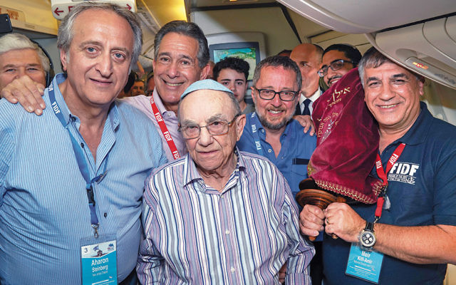 Aharon Steinberg of Ringwood, at left, and Holocaust survivor Leon Shear celebrate their bar mitzvah on the FIDF flight from Poland to Israel on April 16.
