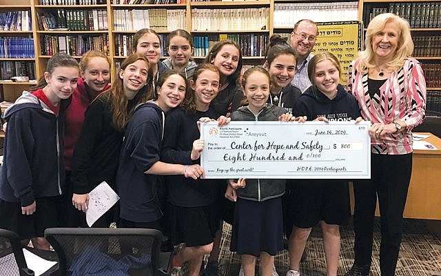 Yeshivat Noam’s young philanthropists present a check to Jean Kirch, the director of development at the Center for Hope and Safety.