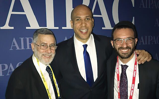 Senator Cory Booker stands between
Rabbi Menachem Genack and his son, Rabbi Yitzy Genack. Senator Cory Booker stands between
Rabbi Menachem Genack and his son, Rabbi Yitzy Genack.