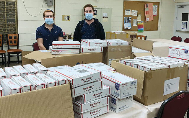 Zalmy and Mendy Kanelsky with the mishloach manot boxes that they helped pack.