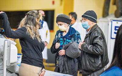 Above and below, staff at the JCC MetroWest welcomes Holocaust survivors as they arrive for their covid vaccines. (JCC MetroWest)