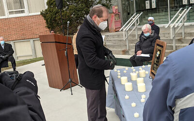 Rabbi Craig Scheff lights a candle at the memorial.