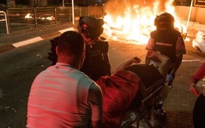Medics evacuate an injured man during clashes between Arab and Jews in Acre, northern Israel, May 12, 2021. (Roni Ofer/Flash90)