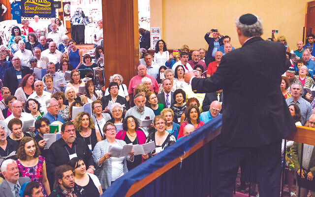 In a pre-covid festival, Matthew Lazar conducts a choir. (Zamir Choral Foundation)