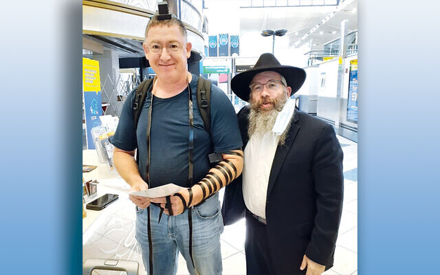 Rabbi Dovid Wilansky and a passenger at Newark Liberty Airport (Courtesy Bris Avrohom)