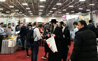 People arrive at Kosherfest in Secaucus with empty tote bags on each shoulder, ready to fill up with product samples and vendors’ business cards. (Photos by Julia Gergely)