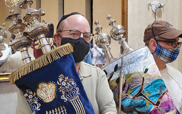 Bruce Yore, left, and David Katz, co-chairs of the congregation’s outreach and engagement committee, hold the Torah scrolls. (Rhonda J Hodas Hack)