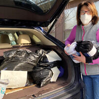 As part of its monthly Community Affairs collection drive, the JCC of Paramus/Congregation Beth Tikvah donated 172 pairs of socks and $250 for the JFNNJ collection. Here, Rima Rosenstein fills her car with donations that had been left at the shul to deliver to JFNNJ.