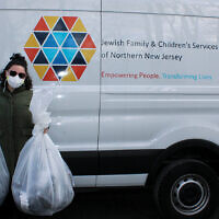 Tori Cappo picks up socks to be distributed by Jewish Family & Children’s Services of Northern New Jersey.