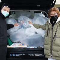 Sister Anna Maria Not and Susan Colacurcio of the Franciscan Community Development Center fill their van with donations.