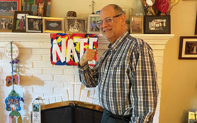 Nate Geller at home in Teaneck. A colleague's daughter made the "Nate" sign, which he took home and hung on his mantel.