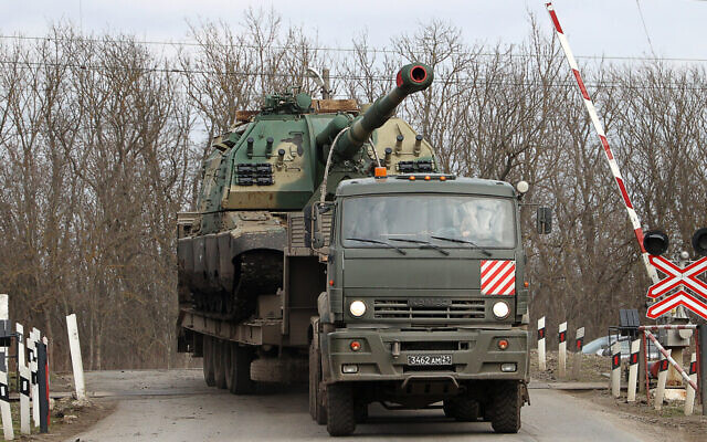 An army truck carries a self-propelled howitzer in Pokrovskoye, Russia, Feb. 21, 2022. (StringerTASS via Getty Images)