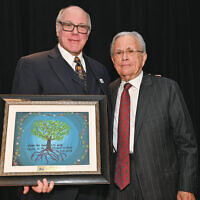 David Shapiro, a past president of the Sinai Schools, presents a student-made gift to honoree Ed Ruzinsky.