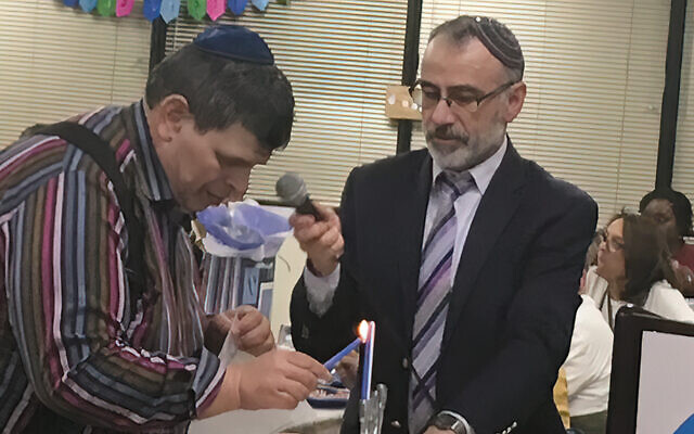 Dr. Winer is at a candle-lighting at a J-ADD Chanukah celebration.