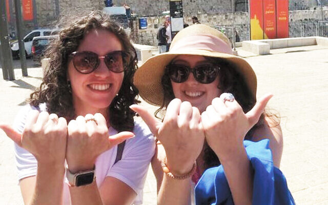 Sydney Albert, left, and Tara Maier holding up the iconic Duke Blue Devils gesture in front of the Western Wall.