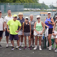 Event co-chair Susan Penn, in the center, wearing black, with participating tennis players