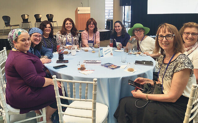 The people at the table reserved for New York metro-area participants include Aviva Rosenberg, left, and Esther Schnaidman, fifth from left, in pink.