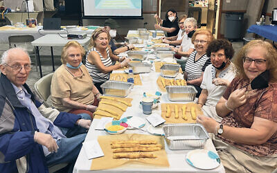 Participants at the JCC of Northern NJ’s Active Seniors program roll out dough to braid four-strand challahs.
