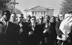 Rabbi Abraham Joshua Heschel, third from left in the front row, and Dr. Martin Luther King, center, take part in a civil rights protest at the Tomb of the Unknown Soldier at Arlington Cemetery on Feb. 6, 1968. Rabbi Maurice Eisendrath holds the Torah. (Charles Del Vecchio/The Washington Post via Getty Images)