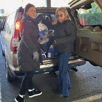 JFNNJ staff members Michal Vinar and Barbara Joyce unload donations in the JFCS parking lot.