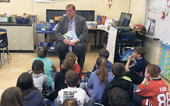 Mr. Hoehmann reads to schoolchildren.