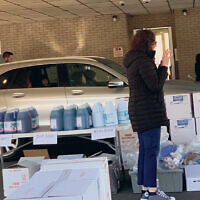 Volunteers loading cleaning supplies into a client’s car.