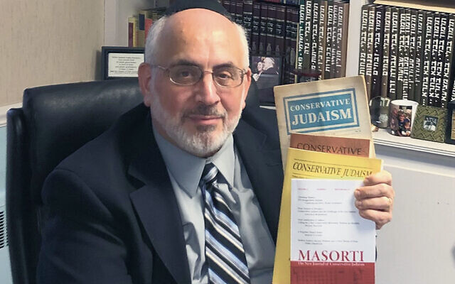 Rabbi Joseph Prouser holds up copies of the new Masorti journal he’s revived.