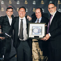 Yachad NJ’s Business Leader Award went to Sean Charnow, second from left, and Jeffrey Wilder, second from right, who presented Micah Lippe, left, with the Employee of the Year award. Rabbi Mark Karasick displays the award.