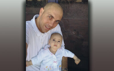 Oded Grinstein holds his baby, who then had a rare cancer, more than a decade ago. She’s cured now, and he works to help other children find the treatments they need.