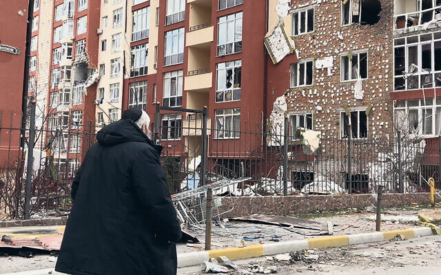 Ukraine’s Rabbi Moshe Reuven Azman looks at the devastation left by Russian bombs. (All photos courtesy Mitzvah for Ukraine)