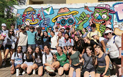 The whole group from TAC poses during a grafitti tour in Tel Aviv.
