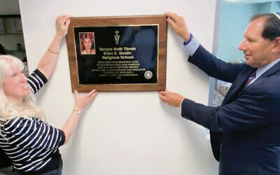 Janice Paul and Rick Hyne, former Temple Beth Tikvah presidents, stand by the plaque.