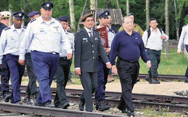 Years ago, Mr. Foxman walks on railroad tracks to Auschwitz on the March of the Living.