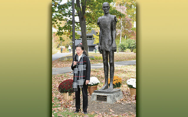 Judith Peck stands next to her sculpture, “One Man in Memory of Six Million.”