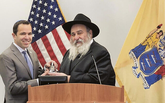 Rabbi Mordechai Kanelsky gives Matthew Platkin a dreidel. (Courtesy Bris Avrohom)