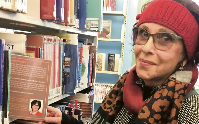Joan Arnay Halperin pulls out a copy of her book at the Hillsdale public library. (All photos courtesy Joan Arnay Halperin)