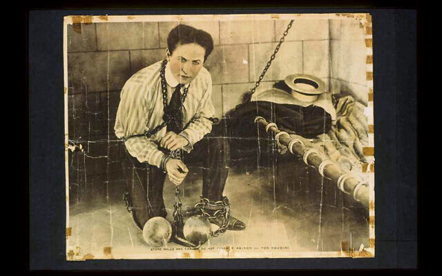 The great escape artist Harry Houdini,  chained, jailed, and about to escape.