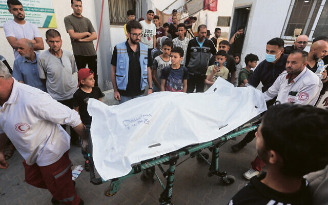 Palestinian workers move the bodies of the World Central Kitchen volunteers who were killed by an Israeli airstrike. (Mohammed/Flash90)